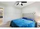 Bedroom with a plush blue bed, tufted headboard, ceiling fan, and a white nightstand at 14715 Fishhawk Preserve Dr, Lithia, FL 33547
