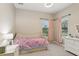 Well-lit bedroom with daybed, two windows, and a dresser featuring modern decor at 14715 Fishhawk Preserve Dr, Lithia, FL 33547