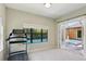 Bright exercise room with a treadmill and views of the pool and outdoor space through a large window and open glass doors at 14715 Fishhawk Preserve Dr, Lithia, FL 33547