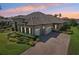 Luxury home featuring stone accents, tile roof, three-car garage, paver driveway, and lush landscaping at 14715 Fishhawk Preserve Dr, Lithia, FL 33547