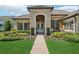 Charming home featuring a brick pathway, double door entrance, and professionally landscaped front yard at 14715 Fishhawk Preserve Dr, Lithia, FL 33547