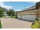Large two car garage features brick facade and large brick paved driveway at 14715 Fishhawk Preserve Dr, Lithia, FL 33547