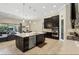 Open kitchen featuring an island with seating, stainless steel appliances, and dark wood cabinets at 14715 Fishhawk Preserve Dr, Lithia, FL 33547
