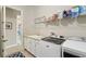 Bright laundry room featuring a sink, washer, dryer, and ample shelving above at 14715 Fishhawk Preserve Dr, Lithia, FL 33547