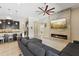 Open-concept living room featuring a stone fireplace, ceiling fan, and gray sectional sofa at 14715 Fishhawk Preserve Dr, Lithia, FL 33547