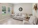 Inviting living room featuring neutral sofa, accent chair, and bright natural lighting at 14715 Fishhawk Preserve Dr, Lithia, FL 33547