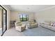 Living room with reclining chairs, a modern sofa, a window view, and a blue geometric rug at 14715 Fishhawk Preserve Dr, Lithia, FL 33547