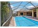 Relaxing screened-in pool and spa with an outdoor seating area and lush tropical backdrop at 14715 Fishhawk Preserve Dr, Lithia, FL 33547