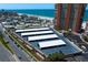 Aerial view of a condo parking area with street access and nearby buildings and ocean at 17920 Gulf Blvd # 1806, Redington Shores, FL 33708