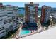 Aerial view of a building with an outdoor community pool, lounge chairs and palm trees near a white sand beach at 17920 Gulf Blvd # 1806, Redington Shores, FL 33708