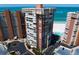 Dramatic aerial view of a beachfront condo tower featuring a pool, beach access, and ocean views at 17920 Gulf Blvd # 1806, Redington Shores, FL 33708