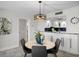 Cozy dining area adjacent to the kitchen features a modern light fixture and seating for four at 17920 Gulf Blvd # 1806, Redington Shores, FL 33708