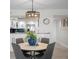 Bright dining area with pendant lighting next to a kitchen with white cabinets and granite countertops at 17920 Gulf Blvd # 1806, Redington Shores, FL 33708
