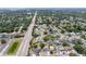 Wide aerial view of a residential neighborhood with tree-lined streets and various home styles, extending to the water at 1818 Willow Oak Dr, Palm Harbor, FL 34683