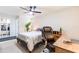 Bright bedroom featuring a ceiling fan, desk, and walk-in closet at 1818 Willow Oak Dr, Palm Harbor, FL 34683