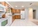 Functional kitchen with white appliances, wood cabinets, and ample counter space for meal preparation at 1818 Willow Oak Dr, Palm Harbor, FL 34683