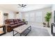 Inviting living room with a brown leather sofa, ottoman, a ceiling fan and plants, creating a comfortable atmosphere at 1818 Willow Oak Dr, Palm Harbor, FL 34683