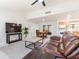 Cozy living room featuring a comfortable brown leather sofa, decorative rug, and a view of the kitchen and dining area at 1818 Willow Oak Dr, Palm Harbor, FL 34683