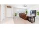 Bright living room with tile floors, carpet, a brown leather sofa, and a modern ceiling fan at 1818 Willow Oak Dr, Palm Harbor, FL 34683