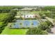 Aerial view of community amenities including a pool, tennis courts, and surrounding greenery at 19635 Bellehurst Loop, Land O Lakes, FL 34638