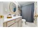 Bathroom featuring a decorative mirror, a granite countertop, and a shower with a blue curtain at 19635 Bellehurst Loop, Land O Lakes, FL 34638