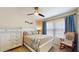 Cozy bedroom with neutral walls, ceiling fan, closet, rocking chair, and a full sized bed at 19635 Bellehurst Loop, Land O Lakes, FL 34638