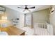 Cozy bedroom with light green walls, ceiling fan, closet, and a crib at 19635 Bellehurst Loop, Land O Lakes, FL 34638