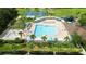 Aerial view of a resort-style pool and recreation area with palm trees and sun loungers at 19635 Bellehurst Loop, Land O Lakes, FL 34638