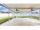 Spacious screened porch with ceiling fans, offering a relaxing outdoor living space with a view of the fenced backyard at 19635 Bellehurst Loop, Land O Lakes, FL 34638