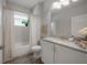 Well-lit bathroom features a granite vanity, toilet, tub-shower combo, and wood-look flooring, blending style and function at 212 Villa Luna Ln, Lutz, FL 33549