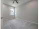 A bedroom features neutral carpet, a ceiling fan, and a bright window, providing a calming and well-lit environment at 212 Villa Luna Ln, Lutz, FL 33549
