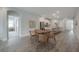 Open dining space with round table, wicker chairs, leading to a modern kitchen and living area at 212 Villa Luna Ln, Lutz, FL 33549