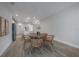 Bright dining area with a round table, wicker chairs, and pendant lighting open to kitchen at 212 Villa Luna Ln, Lutz, FL 33549