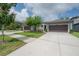 Exterior view of homes with a sidewalk and a driveway leading to a garage at 212 Villa Luna Ln, Lutz, FL 33549