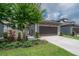 The home has a dark brown garage door and stone accents around the pergola at 212 Villa Luna Ln, Lutz, FL 33549