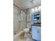 Bathroom featuring a walk-in shower, white vanity, granite counters and modern fixtures at 2750 Edenwood St, Clearwater, FL 33759