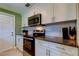 Kitchen with stainless steel microwave and electric oven, white cabinets and granite countertops at 2750 Edenwood St, Clearwater, FL 33759