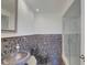 Stylish bathroom featuring modern mosaic tile accents, a glass-enclosed shower, and a sleek, unique stone sink at 31 Freshwater Dr, Palm Harbor, FL 34684