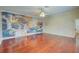 Bedroom boasting gleaming hardwood floors, colorful wall art, and modern ceiling fan at 31 Freshwater Dr, Palm Harbor, FL 34684