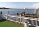 View of a backyard dock and calm waterway featuring a boat lift and a white picket fence overlooking the tranquil water at 31 Freshwater Dr, Palm Harbor, FL 34684