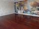 Spacious living room featuring glossy cherry wood flooring and a scenic mural, creating a unique and stylish atmosphere at 31 Freshwater Dr, Palm Harbor, FL 34684