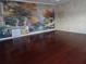 Spacious living room featuring glossy cherry wood flooring and a scenic mural, creating a unique and stylish atmosphere at 31 Freshwater Dr, Palm Harbor, FL 34684