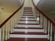 Elegant cherry wood staircase with bright white accents, creating a sophisticated transition between floors at 31 Freshwater Dr, Palm Harbor, FL 34684