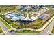 An aerial view showcasing a community clubhouse, pool, playground, and green spaces in a residential area at 31355 Amberview Bnd, Wesley Chapel, FL 33545