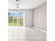 Open-concept living room featuring tile floors and sliding glass doors to the back yard at 31355 Amberview Bnd, Wesley Chapel, FL 33545