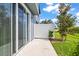 Cozy patio with sliding glass doors, a privacy fence, and lush green grass, perfect for outdoor living at 31355 Amberview Bnd, Wesley Chapel, FL 33545