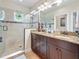 Bathroom boasts a large shower, dual sink vanity with dark cabinets and granite countertop at 3138 Nautical S Pl, St Petersburg, FL 33712