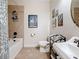This bathroom has a shower and tub, and a pedestal sink with decorative artwork on the walls at 3138 Nautical S Pl, St Petersburg, FL 33712