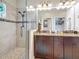 Bathroom boasts a large shower, dual sink vanity with dark cabinets and granite countertop at 3138 Nautical S Pl, St Petersburg, FL 33712