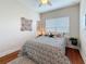 Inviting bedroom with window, decorative artwork, hardwood floors, a cozy bed, and ceiling fan at 3138 Nautical S Pl, St Petersburg, FL 33712
